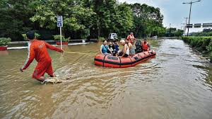 Swollen river in India breaching danger level with warning sign and rescue boat in background